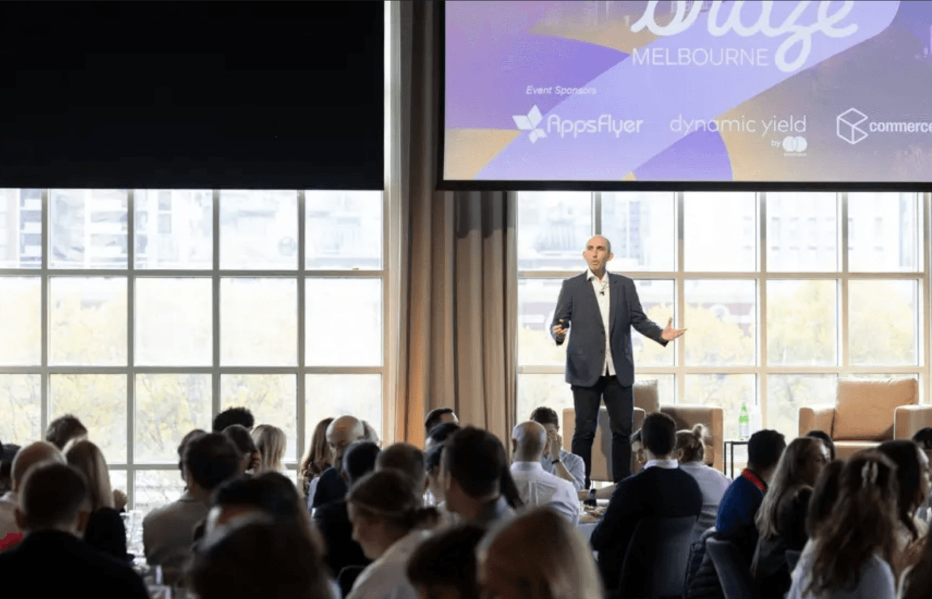 a man stands in front of a screen that says melbourne on it