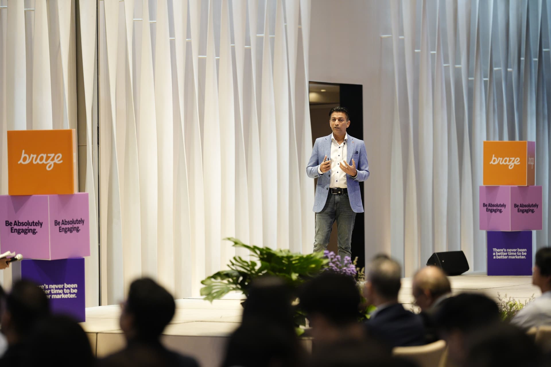 a man is standing on a stage giving a presentation to a group of people .